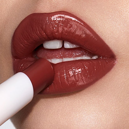 Lips close-up of a light-tone model applying a berry shade lipstick lip balm.