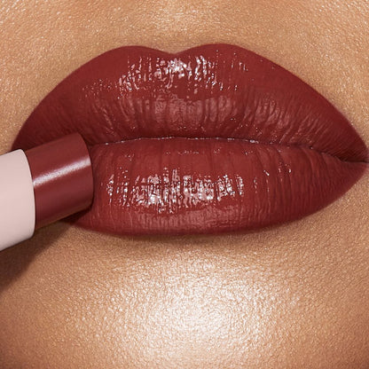 Lips close-up of a light-tone model wearing a peachy nude rose lipstick lip balm.