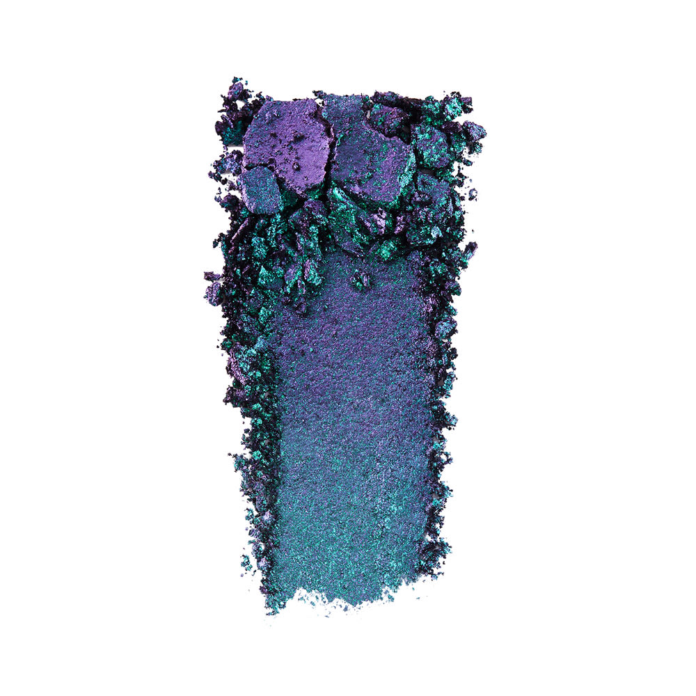 Swatch of an iridescent duochrome purple and teal eyeshadow with very fine shimmer.