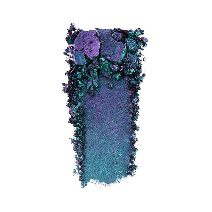 Swatch of an iridescent duochrome purple and teal eyeshadow with very fine shimmer.