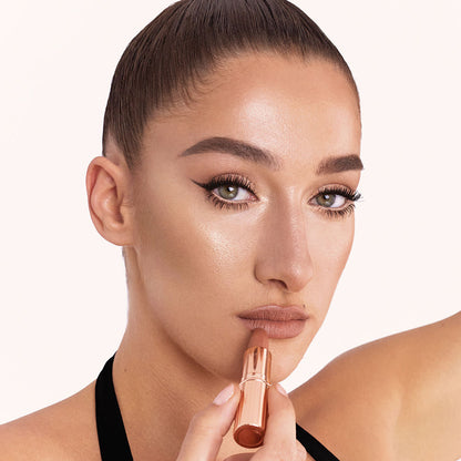 Light-tone model with blue eyes wearing soft beige and champagne eyeshadow with a fresh, neutral nude peach lipstick with a matte finish.