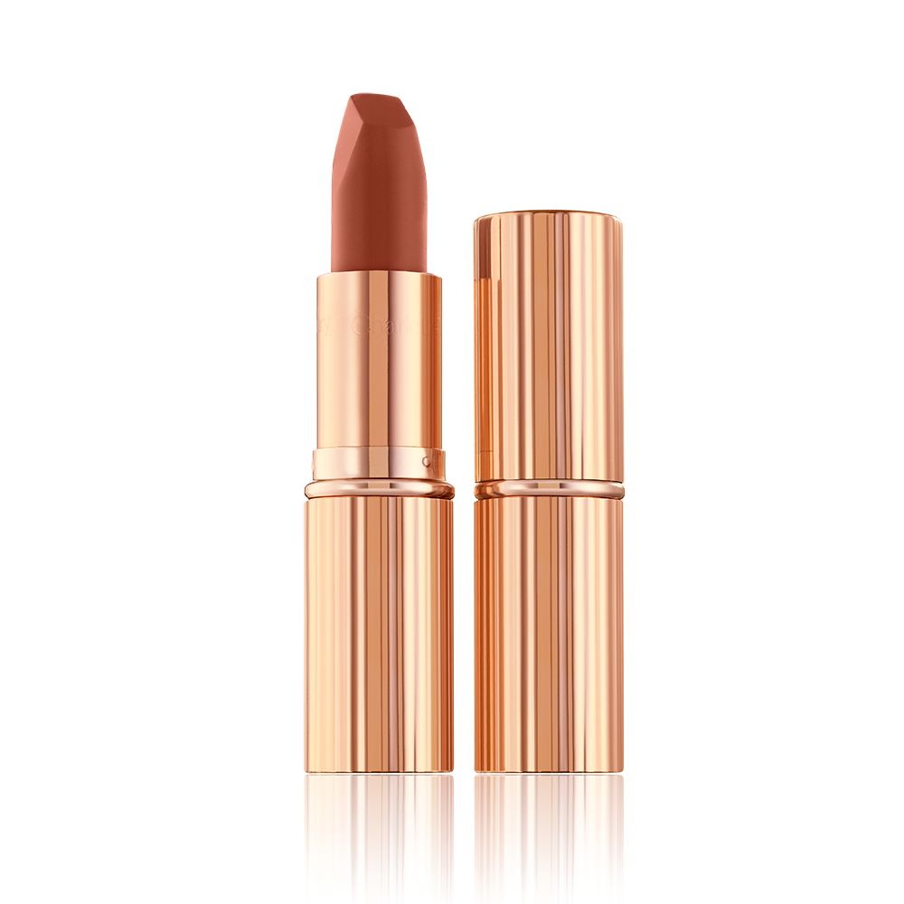 Two lipsticks, with and without lid, in a deep, sultry rose-brown nude matte shade, in sleek, gold-coloured tubes.