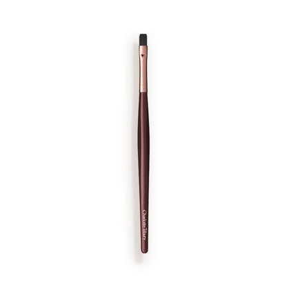 A slim lip brush in dark crimson and gold colour scheme.