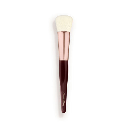 A face blending brush with cream-coloured bristles with a rose-gold and dark crimson handle.