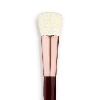 A face blending brush with cream-coloured bristles with a rose-gold and dark crimson handle.