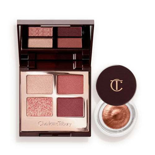 An open, mirrored-lid quad eyeshadow palette with beige, rose gold, russet brown, and maroon shades and cream eyeshadow in a nude pink shade in a petite, open pot with its lid removed.