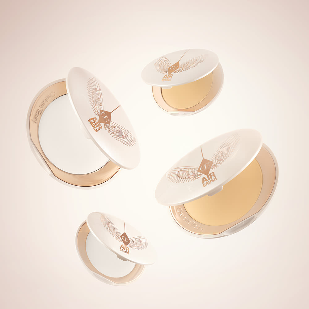 A collection of open, setting powder compacts in two shades, fair to light and medium to deep, in white and gold-coloured packaging.