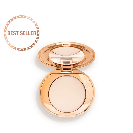 An open, mirrored-lid, mini, pressed powder compact in a cream colour.