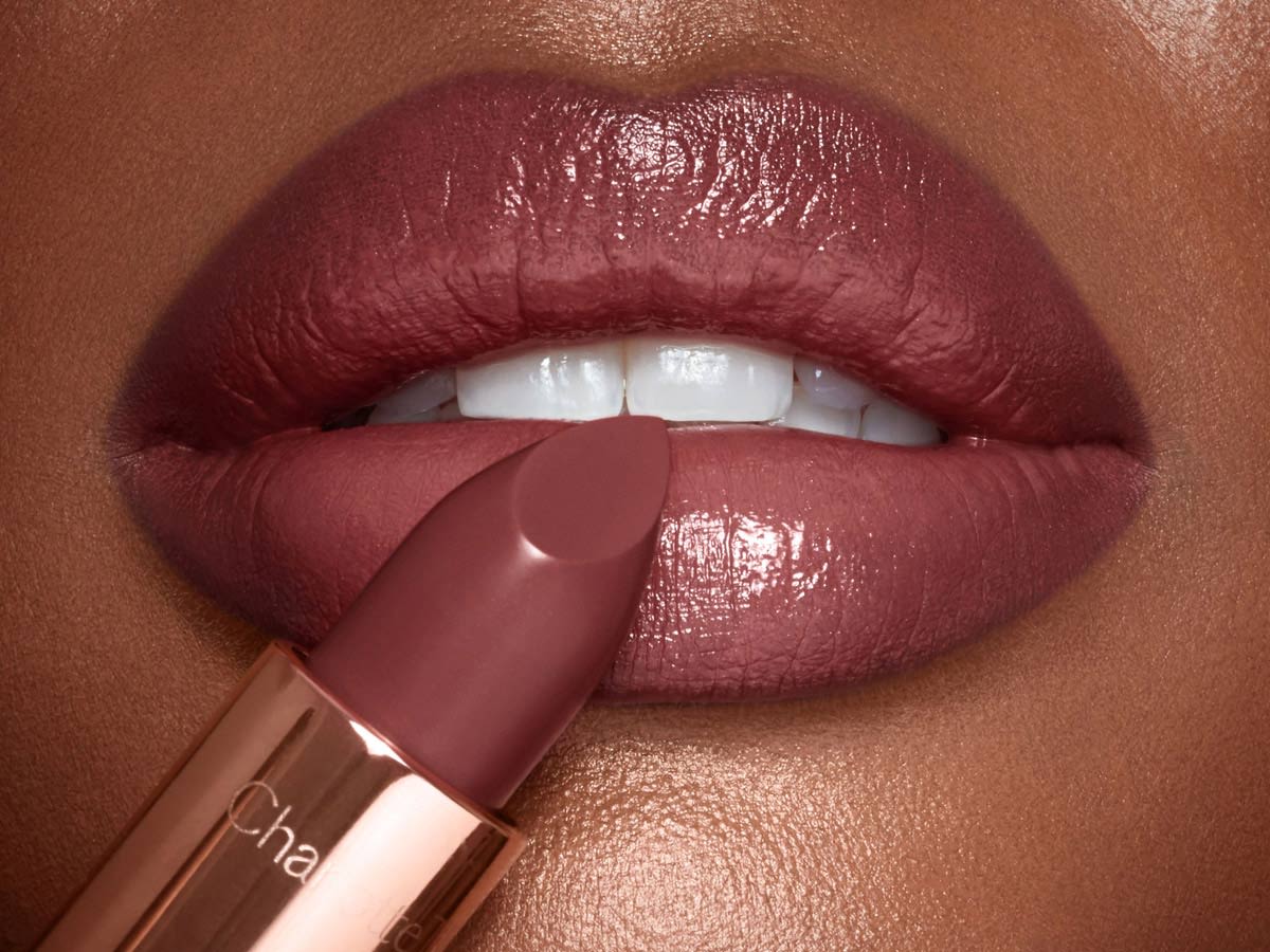 Deep model lip close-up with nude lipstick for dark skin in berry-brown shade with a satin finish.