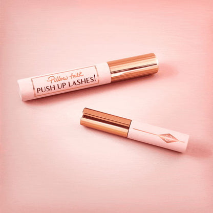 A full-size and travel-size black-coloured mascaras in nude pink bottles with gold-coloured lids.