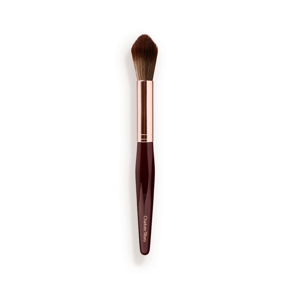 A powder brush with soft bristles and the handle in a dark crimson and rose-gold colour scheme.