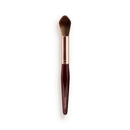 A powder brush with soft bristles and the handle in a dark crimson and rose-gold colour scheme.