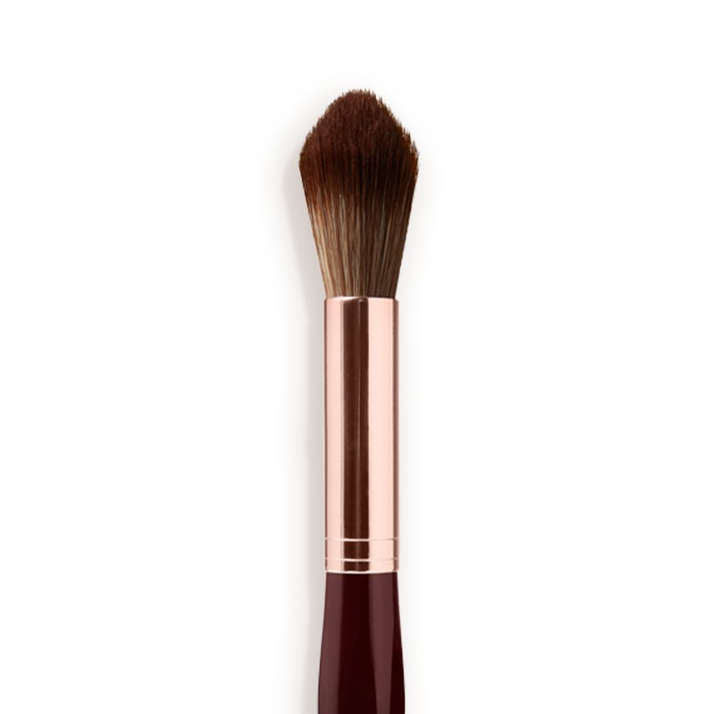 Close-up of a powder brush with brown-coloured bristles with a rose-gold and dark crimson handle.