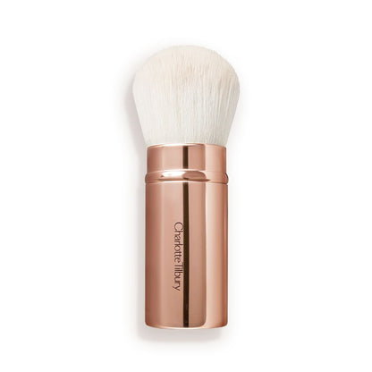 A face blending brush with white bristles in rose gold packaging.