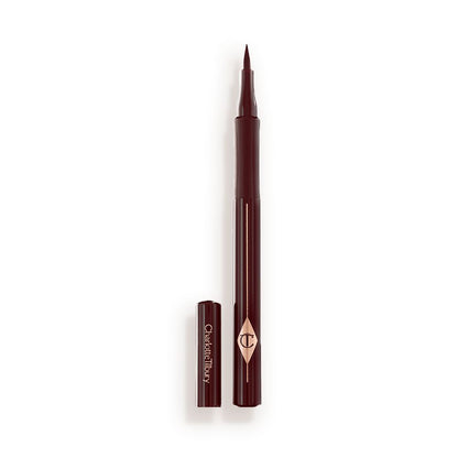 An open, chocolate brown eyeliner pen with a felt tip, a CT symbol embossed on it, and its cap next to it.