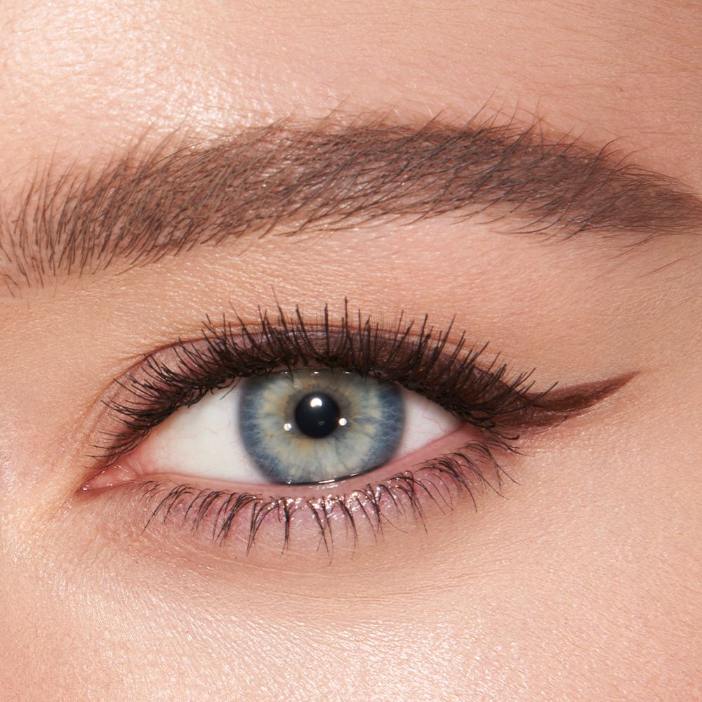 Eye close-up of a fair skin model with blue eyes wearing a chocolate-brown eyeliner in a soft wing.