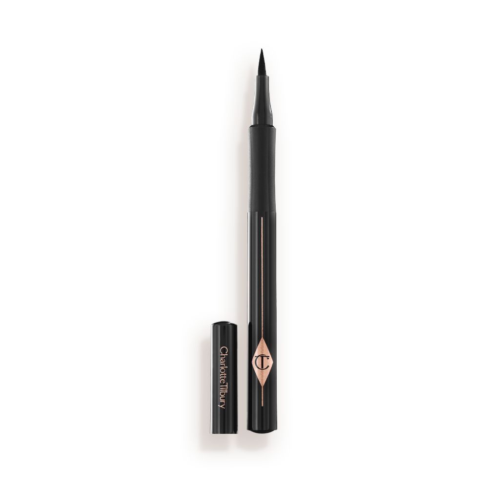 An open eyeliner pen in jet-black packaging with the iconic CT logo embossed on it and its cap next to it.