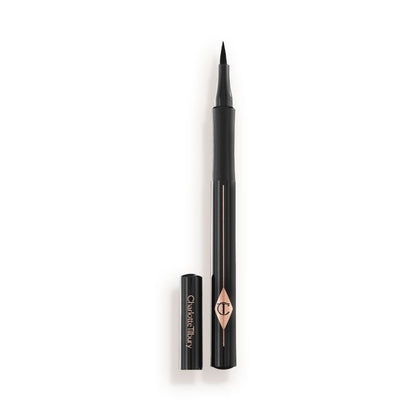 An open eyeliner pen in jet-black packaging with the iconic CT logo embossed on it and its cap next to it.