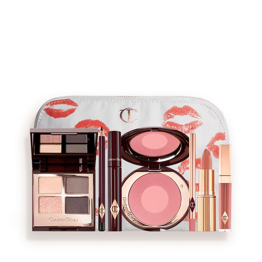A makeup bag with 7 makeup products, which are a quad eyeshadow palette in shades of champagne, greys and pink, dark brown eyeliner pencil, mascara, a two-tone pearlescent pink powder blush, nude pink liner, a peach-toned nude lipstick, and a soft pink lip gloss.